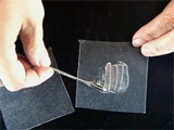 Hand spreading small amount of substance on LC film