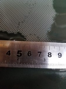 Hundreds of tiny bubbles with centimeter ruler for scale