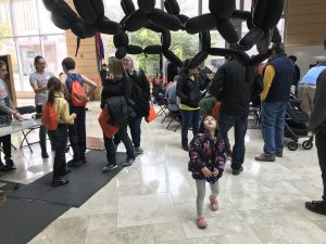 a child marvels at the carbon nanotube balloon, with volunteers in the background