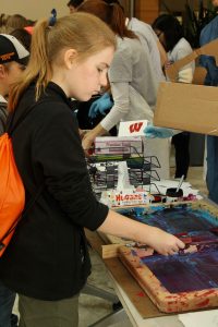 A child screen prints at the WI Science Festival